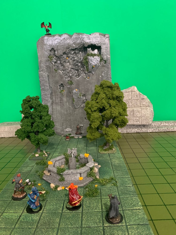 The base photo for a green screen image featuring a scene with miniatures from an upcoming roleplaying game.